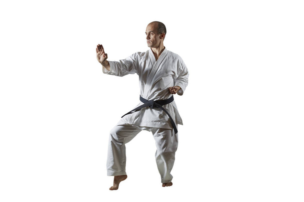 Na bílé izolované pozadí dospělý atlet dělá formální cvičení karate - Fotografie, Obrázek