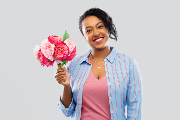 happy african american woman with bunch of flowers - Photo, image