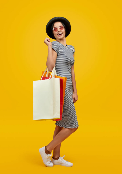 Woman with paper bags looking over shoulder - Foto, imagen