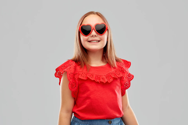 smiling preteen girl with heart shaped sunglasses - Fotó, kép