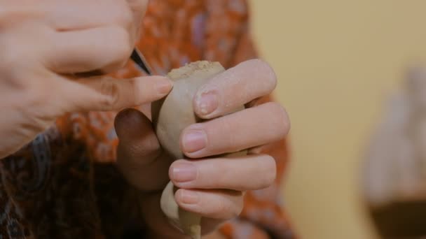 Woman potter making ceramic souvenir penny whistle in pottery workshop - Footage, Video
