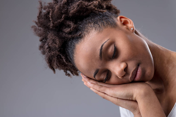 Fatigué jeune femme somnolant avec la tête sur les mains
 - Photo, image
