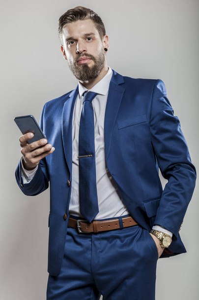 elegante gerente superior exitoso en traje camisa y corbata celebración de teléfono inteligente móvil - Foto, Imagen