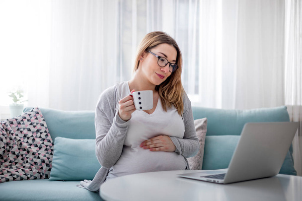 Pregnant woman working online with laptop at home, freelancing concept - Fotografie, Obrázek