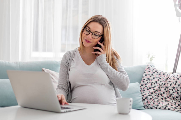 Pregnant woman working online with laptop at home, freelancing concept - Фото, изображение