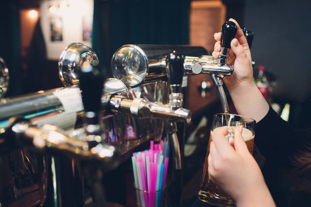 Mans hand pouring pint of beer behind the bar. - Photo, Image