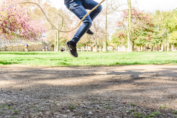 Tyttö pelaa hyppynarua puistossa kesällä
. - Valokuva, kuva