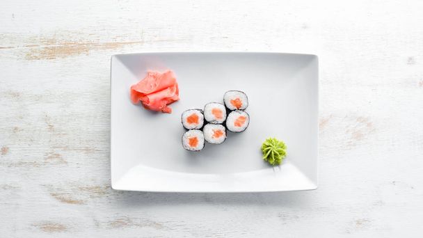Sushi roll maki with salmon. Japanese cuisine. Top view. On a black stone background. - Фото, изображение