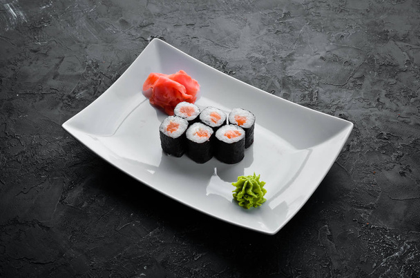 Maki-Sushi-Rolle mit Lachs japanische Küche. Ansicht von oben. auf schwarzem Stein Hintergrund. - Foto, Bild