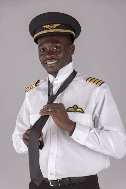  Április 2019. Az egységes fekete nyakkendőjét lekötő pilóta portréja - Fotó, kép