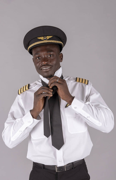  Huhtikuu 2019. Muotokuva lentoyhtiön lentäjä sitoo hänen yhtenäinen musta solmio
 - Valokuva, kuva