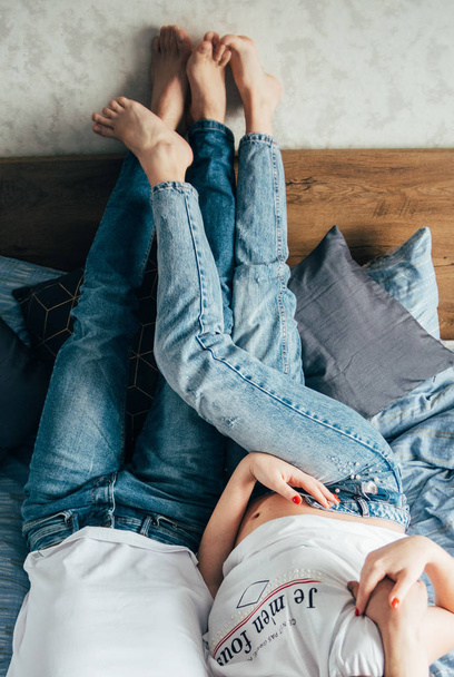 ноги супружеской пары лежат на кровати - Фото, изображение