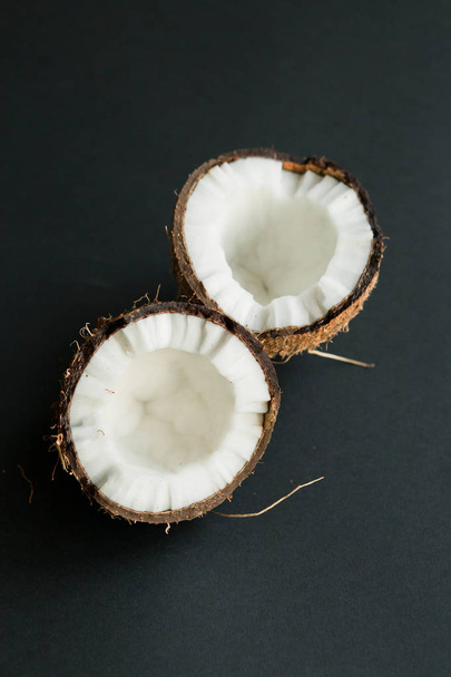 黒い背景に壊れた熟したココナッツ。白い肉 - 写真・画像