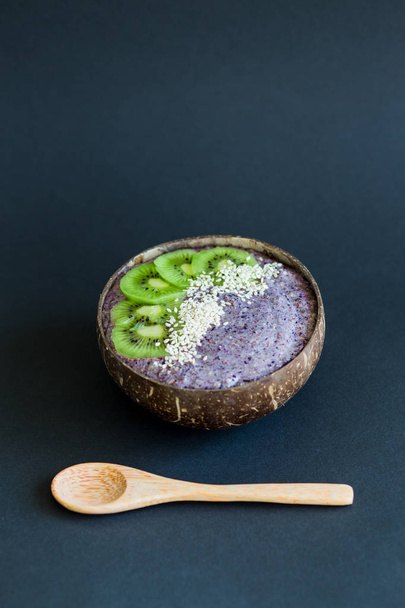 Smoothie saludable, plato hecho de cáscara de coco sobre fondo oscuro
 - Foto, Imagen