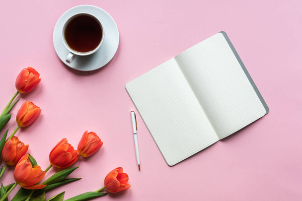 Notebook cup of tea and tulips on pink background. Place for your texy - Photo, Image