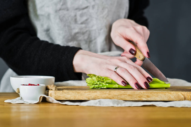 Kokki leikkasi mini parsaa. Sivunäkymä, keittiön tausta, käsite ruoanlaitto parsaa pekonia
 - Valokuva, kuva