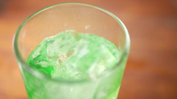 Кубики льоду падіння в ігристе зелена вода - Кадри, відео