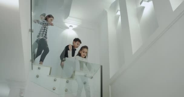 Die charismatischen drei Kinder gehen morgens in den ersten Stock und laufen die Treppe hinunter, um zur Schule zu gehen.. - Filmmaterial, Video