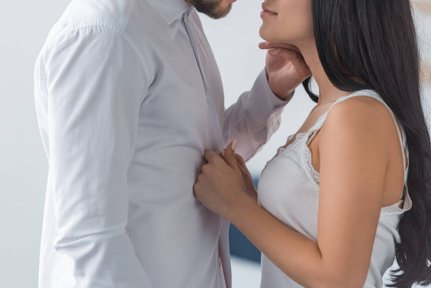 cropped view of brunette woman touching white shirt on boyfriend  - Foto, Imagem
