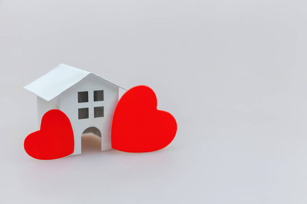 Beyaz arka planda izole kırmızı kalp ile minyatür beyaz oyuncak ev ile sadece minimal tasarım - Fotoğraf, Görsel