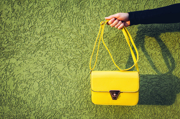Young woman holding stylish yellow handbag. Spring female clothes and accessories. Fashion - Фото, изображение