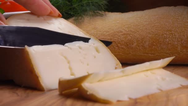 Knife cuts off a piece of soft sheeps cheese - Imágenes, Vídeo