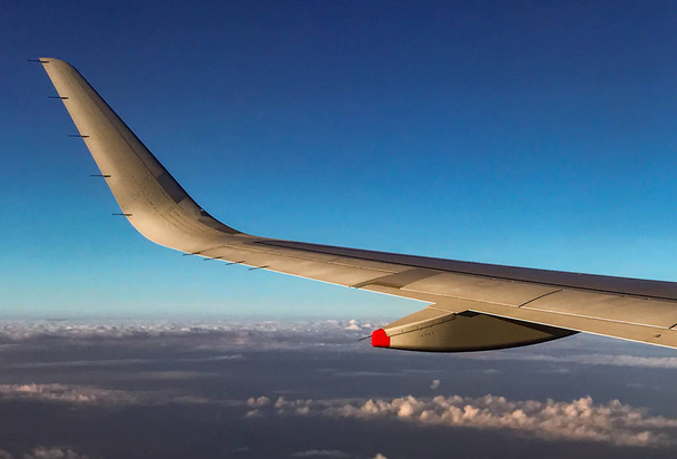 Крыло пассажирского самолета, летящего над землей
 - Фото, изображение