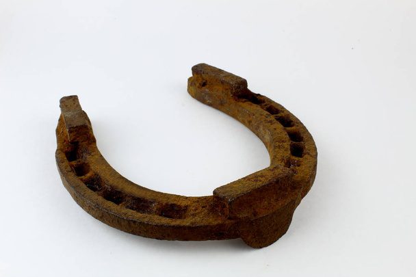 Old rusty horseshoe on a light background. Symbol of good luck and luck. - Photo, Image