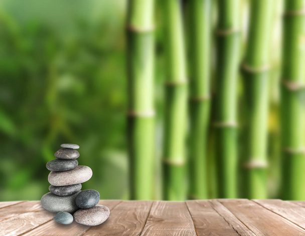 Zen-Steine auf Holztisch im Garten gestapelt, Platz für Text  - Foto, Bild