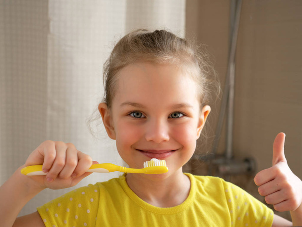 Diş hijyeni. Mutlu küçük kız dişlerini fırçalıyor. - Fotoğraf, Görsel