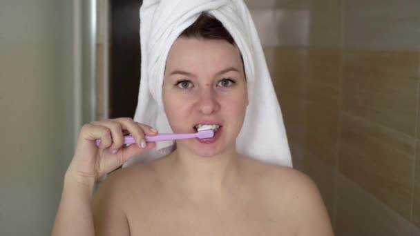 Woman brushing her teeth in modern bathroom - Πλάνα, βίντεο