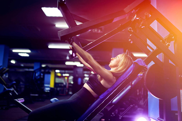 Attractive fit middle age woman athlete doing exercises on pectoral muscles in simulator. Gym Machine - Foto, Imagen