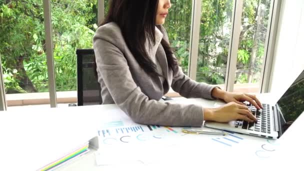 Intelligente donna d'affari asiatica che lavora con il documento di revisione presso l'edificio degli uffici
 - Filmati, video