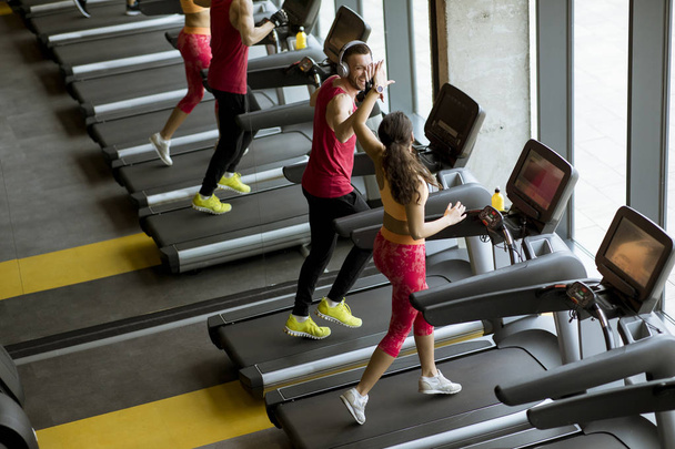 Mężczyzna i kobieta robi cardio treningu na bieżniach w klubie fitness - Zdjęcie, obraz