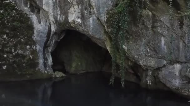 Lento pienen järven yläpuolella kirkkaalla vedellä lähellä luolaa, jossa kevät on
 - Materiaali, video