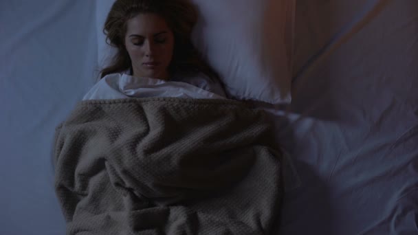 Baş ağrısıdurdurmak ve uykuya dalmak için antidepresan alarak yatakta kadın yatarken - Video, Çekim