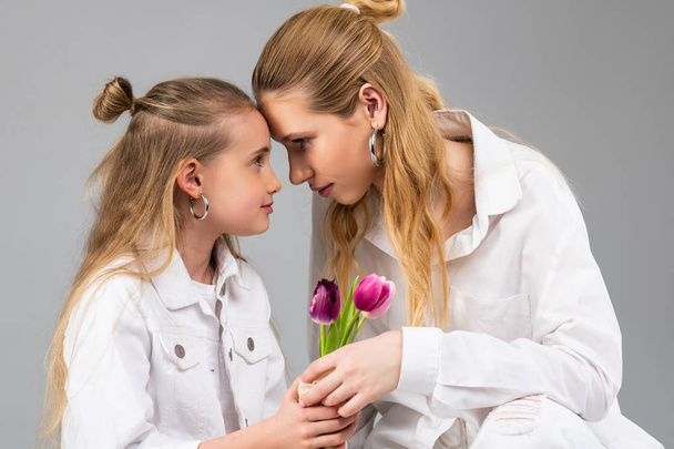 Resolute appealing woman connecting foreheads with her younger sister - Foto, Bild
