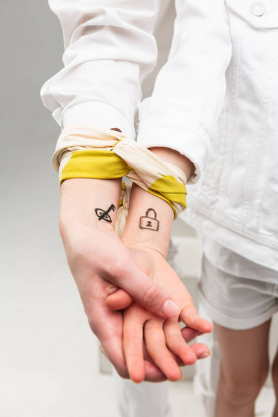 Girls in all white clothes having pictures on their wrists - Фото, изображение