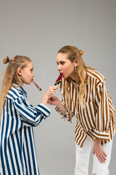 Curious good-looking ladies in funky shirts tasting each other sweets - Фото, зображення