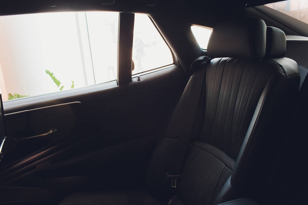 Luxury car inside. Interior of prestige modern car. Comfortable leather seats. Black perforarated leather cockpit. - Zdjęcie, obraz