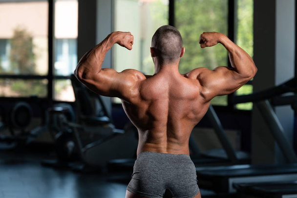 Muscular Men Is Hitting Rear Double Bicep Pose - Фото, изображение