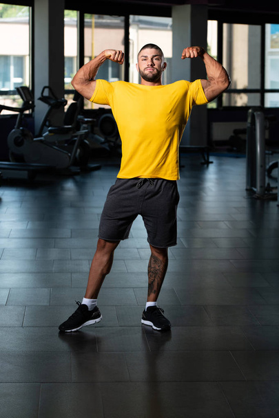 Muscular Man Posing In Yellow T-shirt - 写真・画像