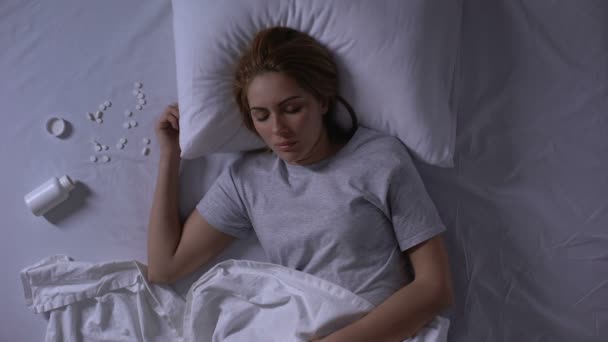 Fiatal nő békésen feküdt az ágyban közelében nyitott jar tablettákkal, túladagolás, öngyilkosság - Felvétel, videó