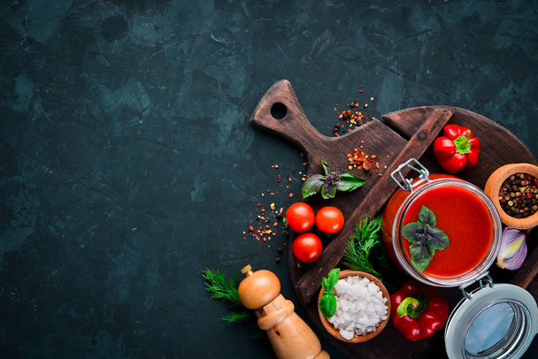 Tomato paste Ketchup with vegetables, homemade. Top view. On a black background. Free space for text. - Foto, afbeelding