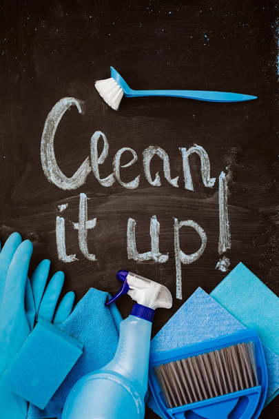 As palavras "limpar tudo! "no quadro-negro acima do kit de limpeza da mola azul
. - Foto, Imagem