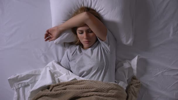 Sad lady lying in bed suffering from intestinal flu feeling nausea and dizziness - Кадри, відео