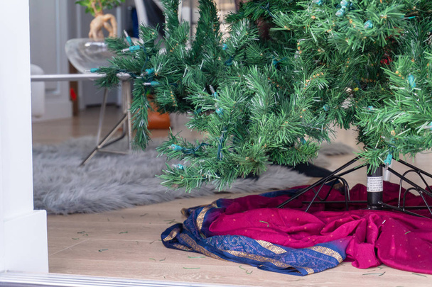 Yapay bir Noel ağacının alt kısmında, süslerle dekore edilmeye hazır, oturma odasında bir stand üzerinde kurmak, ama boş. - Fotoğraf, Görsel