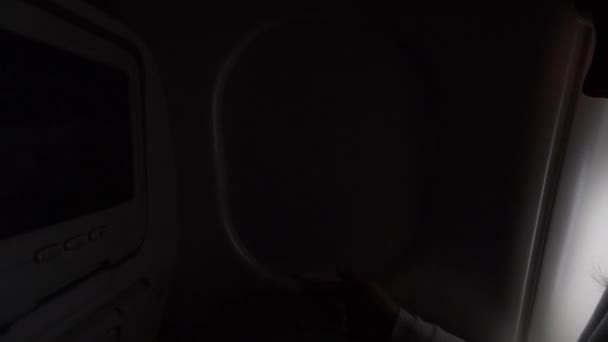 Pov Close Up: A nő kinyitja a repülőgép ablakát, és vakító fényt enged a kabinba - Felvétel, videó