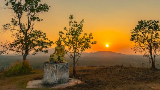 timelapse puesta de sol detrás de un Buda de oro en el hill.scenery puesta de sol detrás de la campana y estatua de Buda de oro en la cima de Baan Ngao templo Rarong provincia Tailandia
.  - Metraje, vídeo