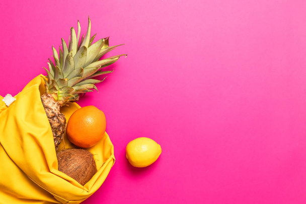 Flat lay. Fresh exotic fruits with a yellow cotton bag on a yellow background - Photo, Image